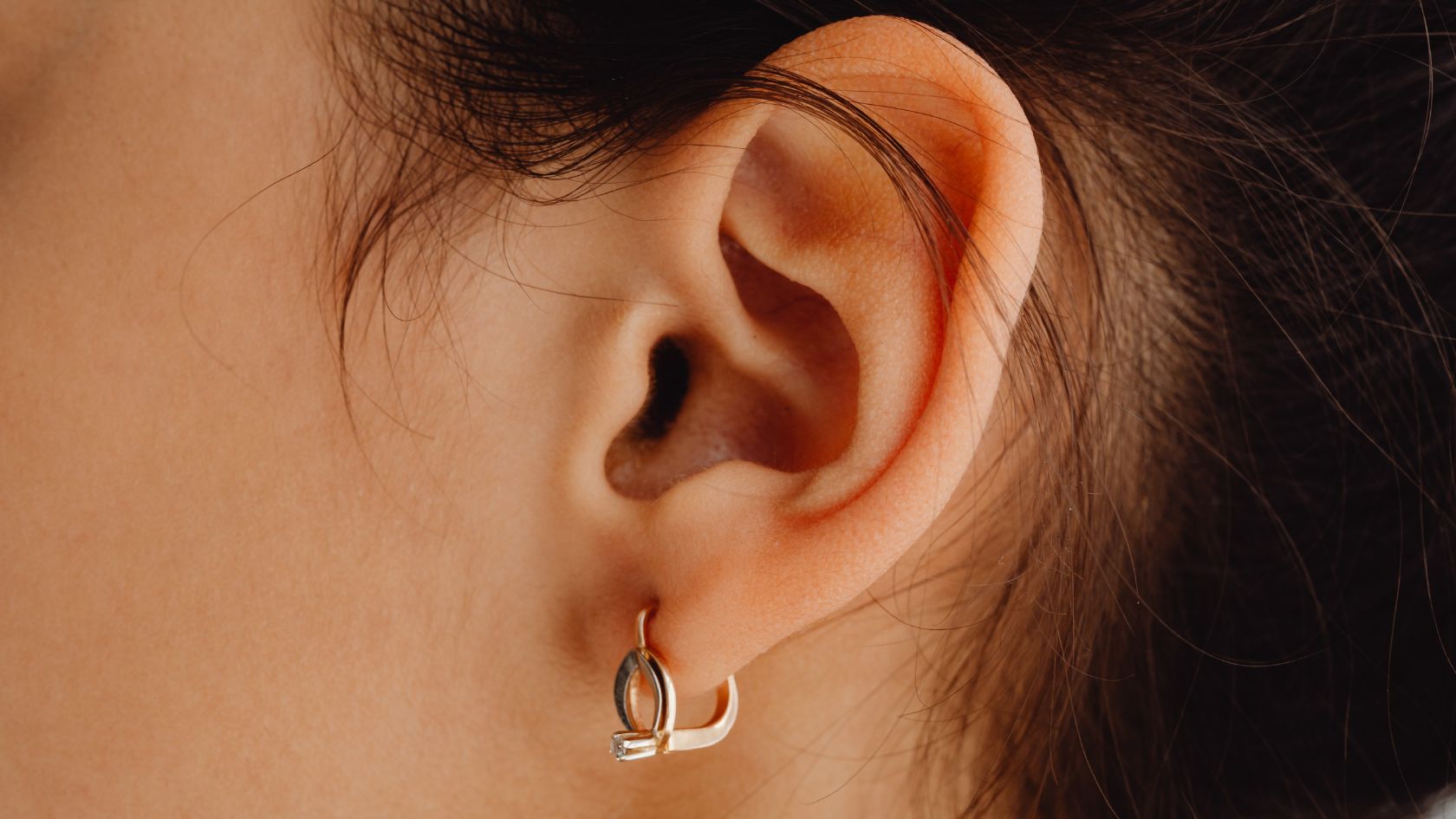 A close up of a person wearing a pair of earrings