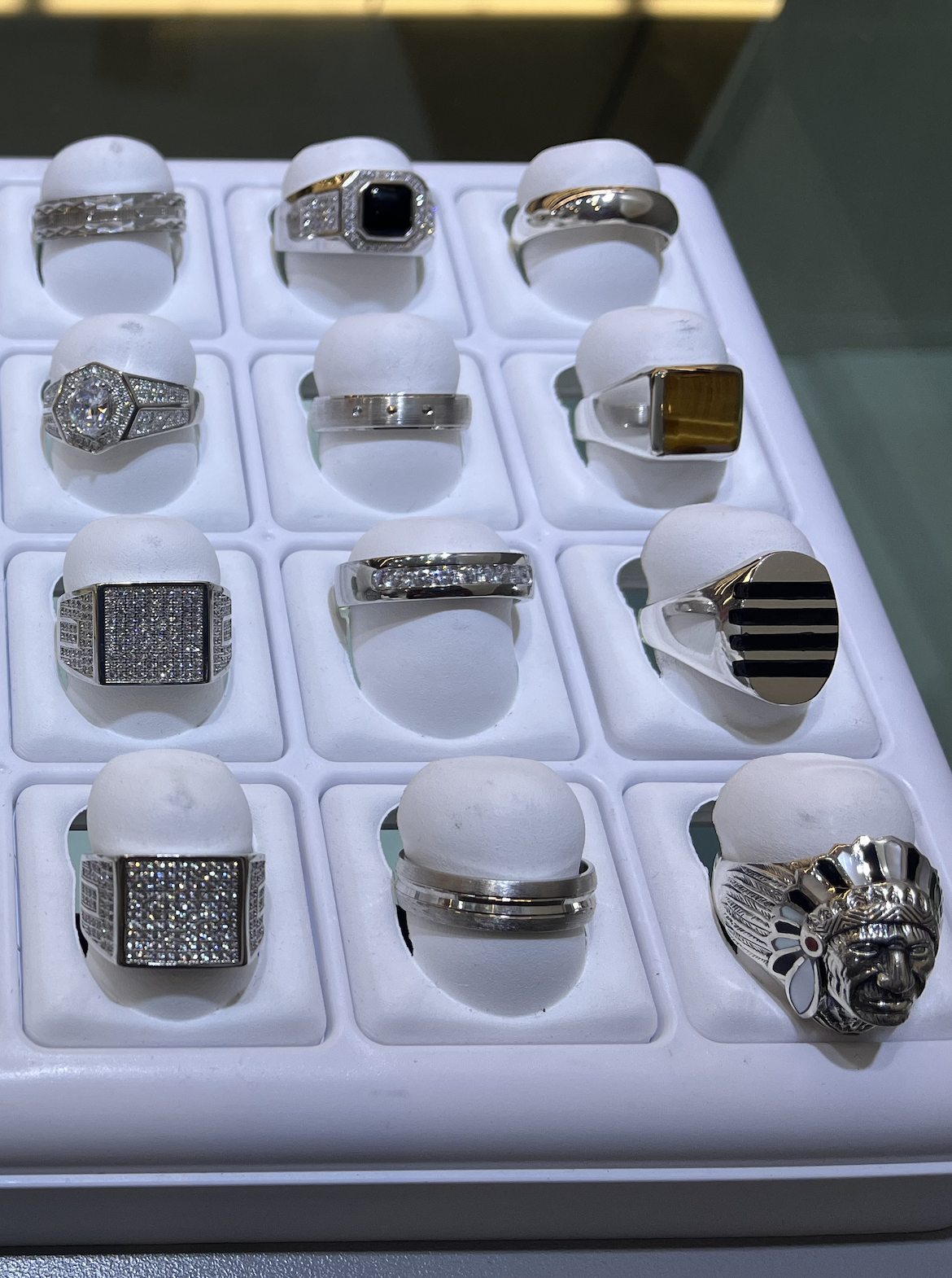 A display case with a variety of rings on it